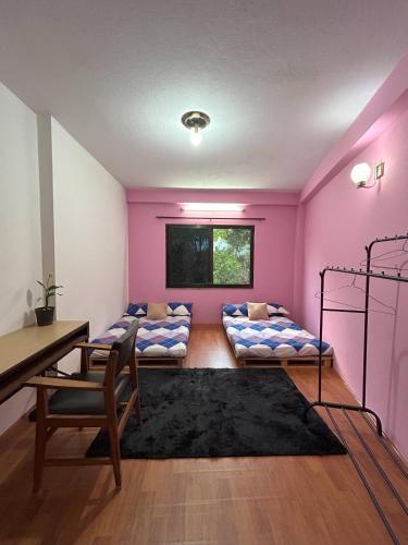 pokój z dwoma łóżkami piętrowymi i biurkiem w obiekcie Happy Homes w Katmandu
