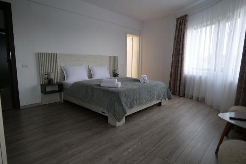 a bedroom with a large bed with white pillows at Pensiunea Agroturistica Darius in Baia de Fier
