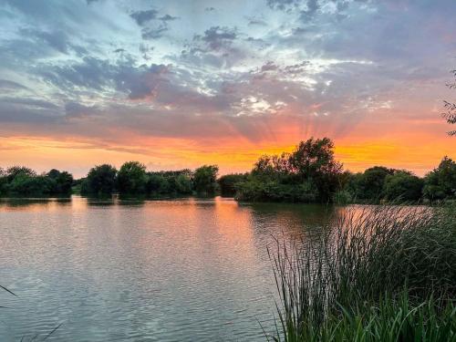 a view of a lake with a sunset in the background at Orchard House - Uk48580 in Rochford