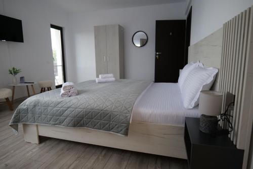 a bedroom with a large bed with a teddy bear on it at Pensiunea Agroturistica Darius in Baia de Fier