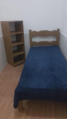 a bedroom with a blue bed and a book shelf at Quarto 001 - Centro de Valença in Valença