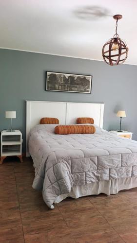 a bedroom with a large white bed with two pillows at Casa Aguaribay- Lomas Altas- in Chascomús