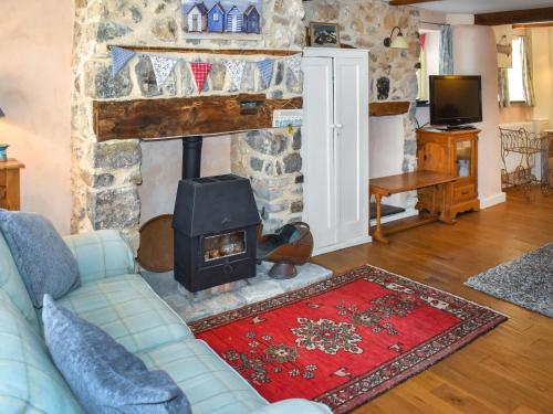 ein Wohnzimmer mit Couch und Kamin in der Unterkunft Primrose Cottage in Seaton