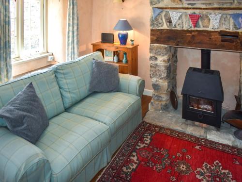 ein Wohnzimmer mit Couch und Kamin in der Unterkunft Primrose Cottage in Seaton