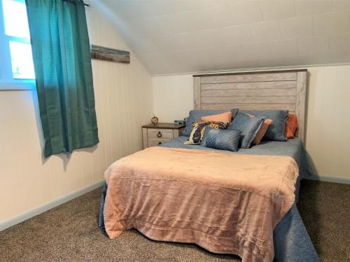 a bedroom with a bed with blue pillows and a window at The Blue Bliss in Saint Ignace