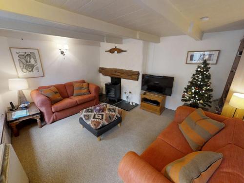 a living room with couches and a christmas tree at Jowders Cottage in Marazion