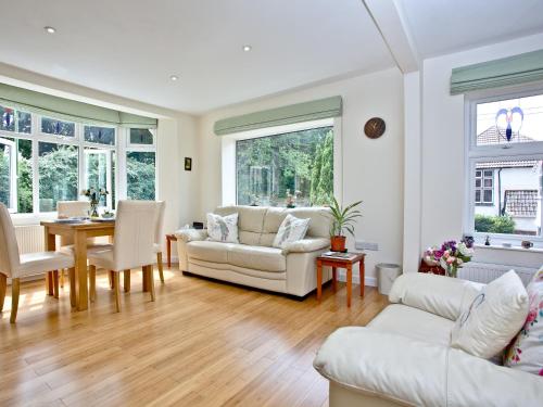 a living room with white furniture and a table at Oldway Apartment in Paignton
