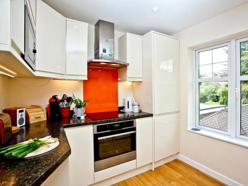 a kitchen with white cabinets and a window at Oldway Apartment in Paignton