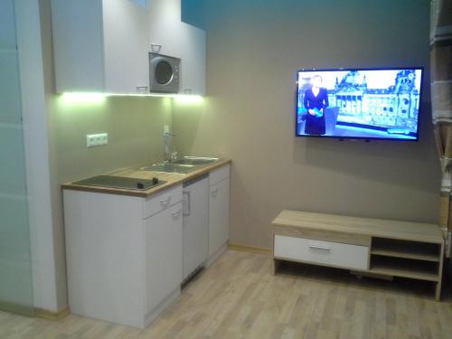 a kitchen with a sink and a tv on the wall at Apartmenthaus Wertheim in Wertheim