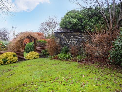 un jardín con una pared de piedra y una valla en Hafanedd, en Dyffryn