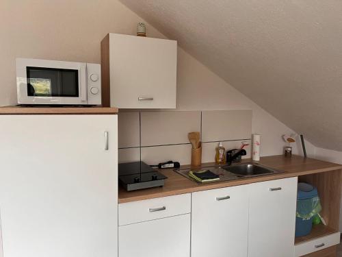 una cucina con forno a microonde e lavandino di Ferienwohnung Oberheuslingen a Freudenberg