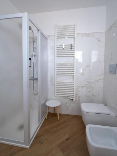 a white bathroom with a toilet and a shower at Essenza Rooms in Crispiano