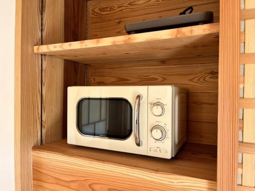 a microwave sitting on a shelf in a cabinet at Matsu no Yu Tokiwa - Vacation STAY 56390v in Yatsushiro