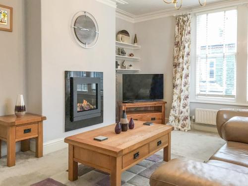 a living room with a fireplace and a tv at Upton Down in Keswick