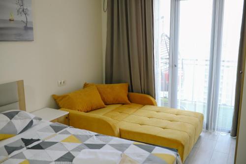 un salon avec un canapé et un lit dans l'établissement Sky Apartments, à Batoumi