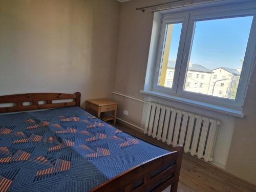 a bedroom with a bed and a large window at Quiet and comfortable apartment in Rakvere