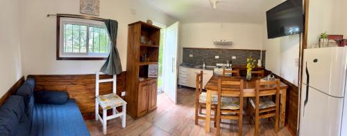 una cocina con mesa y una cocina con refrigerador en Cabaña en Rio Azul Campo Base, en El Bolsón