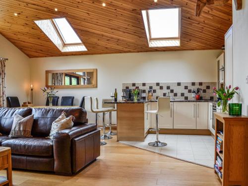a living room with a couch and a kitchen with skylights at Glengoulandie Lodge in White Bridge