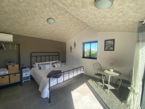 a bedroom with a bed and a table and a window at Chalet Olisios, priate accommodation in beautiful countryside location in Pampelonne