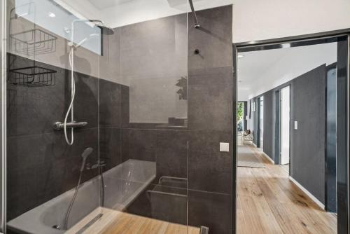 ein Badezimmer mit Dusche und Badewanne in der Unterkunft Koblenz-City am Schloss - 10 Gäste - ZachaStay in Koblenz