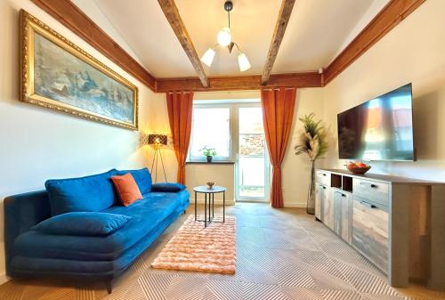 a living room with a blue couch and a tv at Residence S5 - Comfort Living Apartment in Prešov