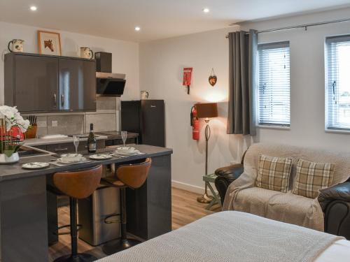 a kitchen and living room with a bar and a couch at Saddlers - Uk50519 in Ovington