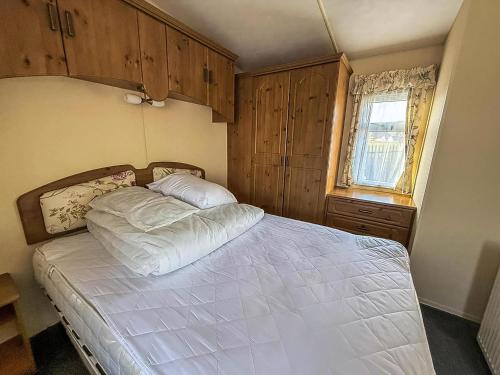 une chambre avec un grand lit blanc et une fenêtre dans l'établissement Great Dog Friendly Caravan For Hire At North Denes In Suffolk Ref 40068Nd, à Lowestoft