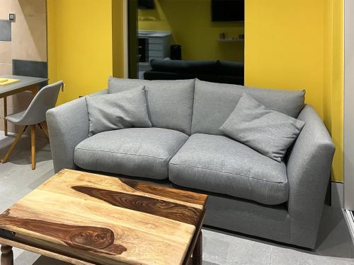 a gray couch in a living room with a coffee table at Peartree Cottage in Sheffield