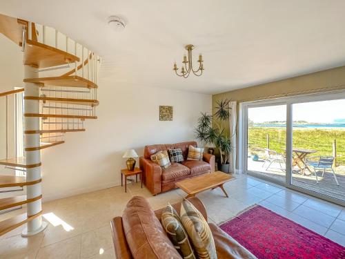 a living room with a couch and a spiral staircase at Sealladh Apartment - Ukc6792 in Port Appin
