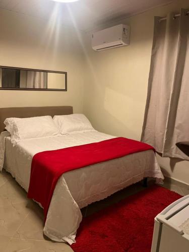 a bedroom with a bed with a red blanket at Sítio Do Manacá in Domingos Martins