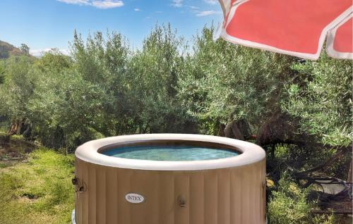 a hot tub in the middle of a field with trees at Beautiful Home In Santa Teresa Di Riva in Capo Mulini