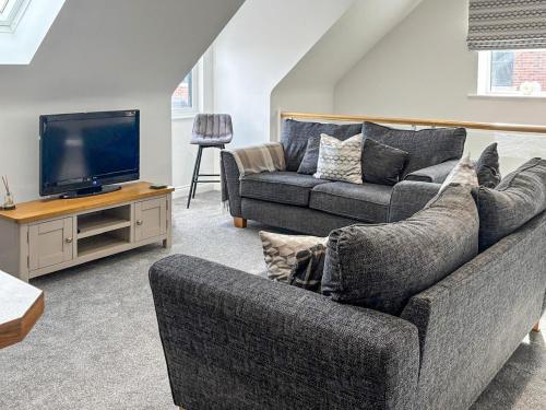 a living room with a couch and a tv at Tilia Loft in Scotter