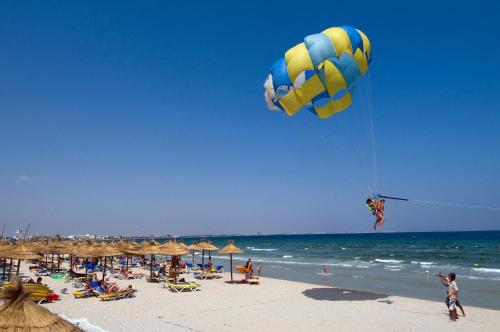 a man is flying a kite on a beach at Royal Thalassa Monastir in Monastir