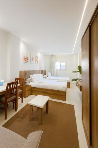 a bedroom with a bed and a desk and a table at Diva Suites in Hurghada