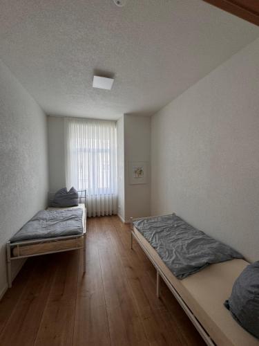 a room with two beds and a window at 2 Bedroom Apartment at Grenzach train station in Grenzach-Wyhlen