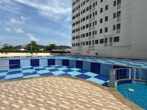 a swimming pool in front of a building at Cozy Studio Near BCS and Grand Batam Mall - with Netflix & free wifi in Nagoya