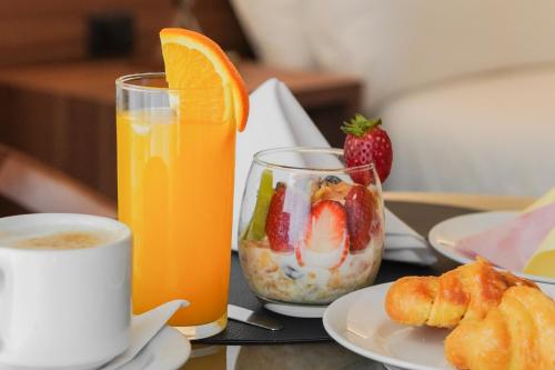 uma mesa com um prato de fruta e um copo de sumo de laranja em Parque Hotel Jean Clevers em Punta del Este