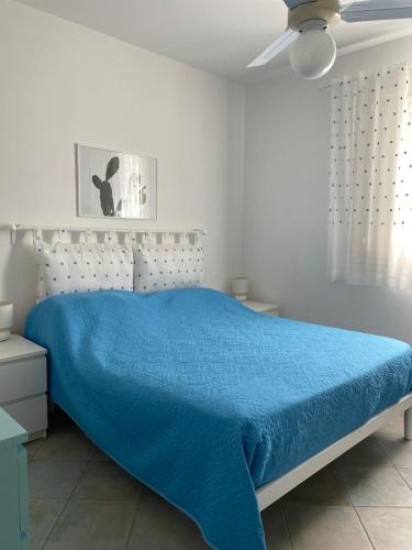a bedroom with a bed with a blue comforter at Residence Sofia a Santa Maria al bagno con piscina in Nardò
