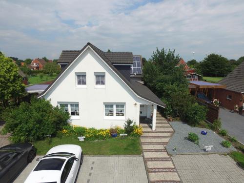a white house with cars parked in front of it at Familie Decker-Behrends in Upleward