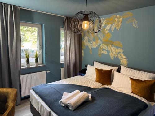 a bedroom with a large bed with a blue wall at Ankommen & wohlfühlen - Ihr stilvolles Zuhause in Dresden