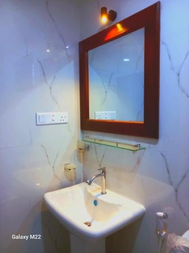 a bathroom with a sink and a mirror on the wall at Mango Villa in Hikkaduwa