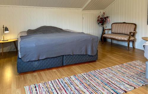 Nice Apartment In Kvalsund With Wifi في Kvalsund: غرفة نوم بسرير وكرسي وسجادة