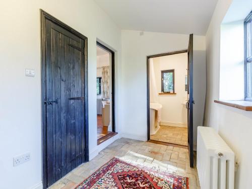 a hallway with a door and a rug at Pettingalls Farm Cottage in Great Ellingham