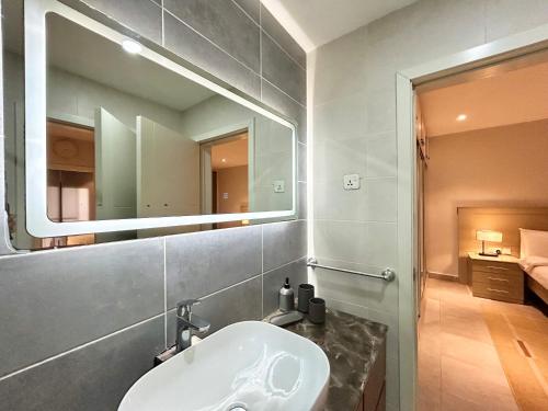 a bathroom with a sink and a mirror at Forest View Apartments in Kololi