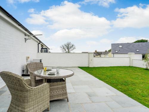 eine Terrasse mit Tisch und Stühlen in einem Hof in der Unterkunft Willow Tree Cottage - Uk35893 in Ludchurch