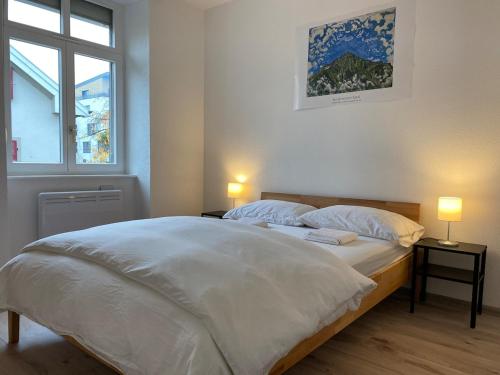 a bedroom with a large white bed with two lamps at City Centre Saint-Louis in Saint-Louis