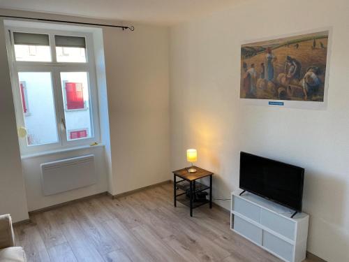 a living room with a flat screen tv and a window at City Centre Saint-Louis in Saint-Louis