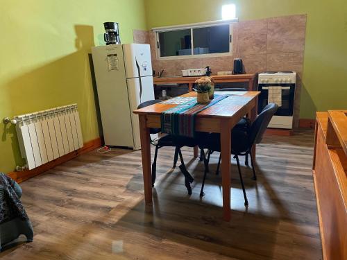 a kitchen with a wooden table and a refrigerator at Cabaña Familia de Campo 2 in El Chalten