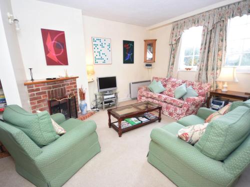 a living room with two couches and a fireplace at Pepper Pot Cottage in Compton