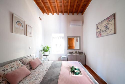 a bedroom with a large bed with pink pillows at My sweet Greek dream - Traditional home in Soroni